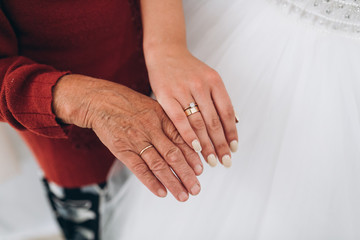 Old grandmother hand and arm young bride in the wedding