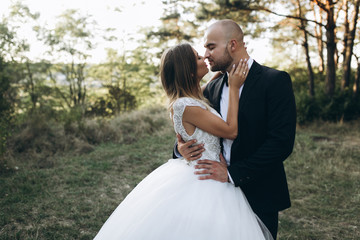 Naklejka premium Stylish bride and bearded muscular groom posing on the wedding