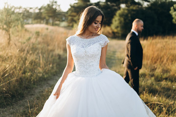 Stylish bride and bearded muscular groom posing on the wedding