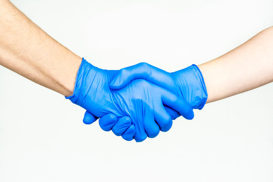 Handshake with blue medical gloves, profile view on white background.