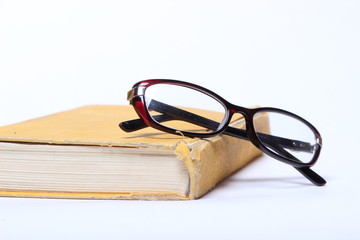 spectacles lying on old book