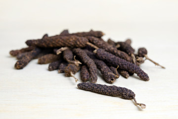 Long pepper or Pipli or Dipli (Piper longum) isolated on wood ba