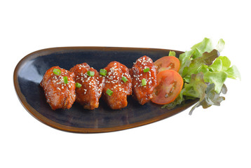 Chicken wings with sauce in ceramic plate on white background
