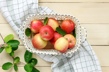 Top view red apple and leaf in basket on wooden.