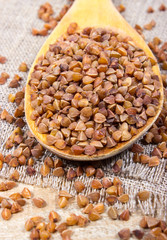 Buckwheat groats on a wooden spoon.