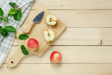 Top view red apple sliced,knife,napkin, leaf on wooden.