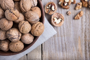 walnuts in a bowl on a wooden background