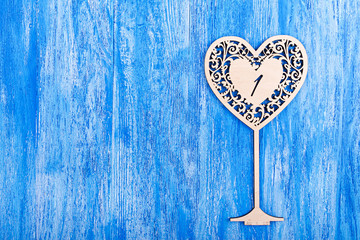 ooden heart carved on a blue wooden background