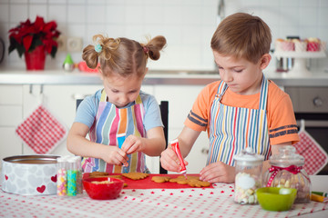 Cute boy and girl preparing Christmas cookies at home