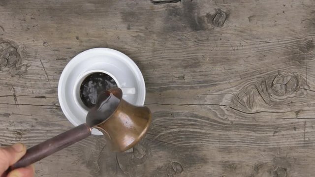 Crockery pouring freshly brewed coffee to a classic cup