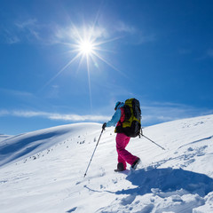 Fototapeta na wymiar Woman is hiking in snowy winter mountains