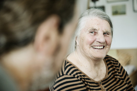 Sohn besucht seine demente Mutter in ihrem Zimmer im Seniorenheim