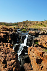 Sud Africa, 01/10/2009: una cascata sulle rocce nere nel canyon che il fiume Truer forma nelle Bourke's Luck Potholes, una formazione geologica nella riserva naturale del Blyde River Canyon