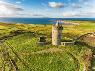 Naklejka premium Antena słynnej irlandzkiej atrakcji turystycznej w Doolin w hrabstwie Clare w Irlandii. Zamek Doonagore to okrągły XVI-wieczny zamek-wieża. Wyspy Aran i wzdłuż The Wild Atlantic Way.