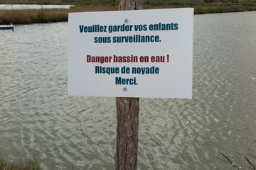 Red danger sign on an ocean beach with waves on the background