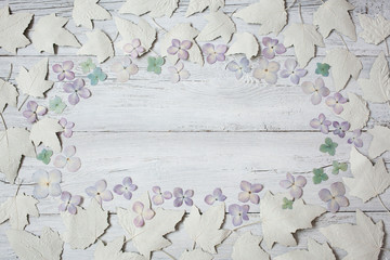 Wooden background with dried leaves and flowers of hydrangea