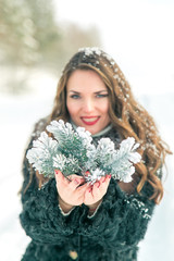 girl with fir branches in the woods on a light background