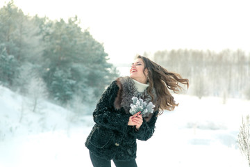 girl with fir branches in the woods on a light background