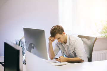 Looking from the working men in the office. Stylish designer at work sitting. Focused on his job businessman