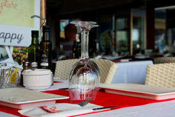 Table setting in a city restaurant with upside down wineglasses, close up