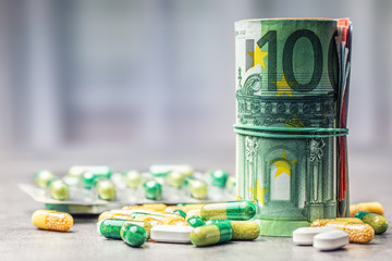 Euro money and medicaments. Euro coins and pills. Rolled euro banknotes stacked on each other in...