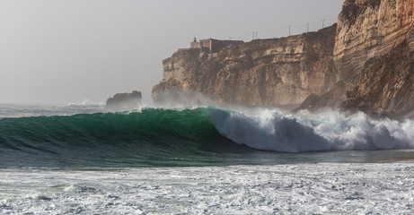 Meereswellen und Klippen in Nazare. Herbsttag an der Atlantikküste in Portugal.