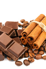 Dark chocolate bar, cubes, cinnamon sticks and coffee beans isolated on white background.