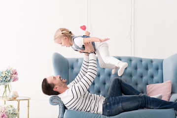 Positive joyful man looking at his daughter