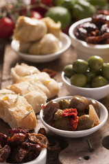 Bread, olives and artichokes served on a wooden table