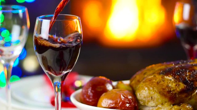 wine pouring to glass on christmas table in front of fireplace