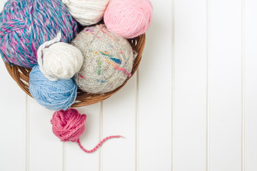 Fototapeta na wymiar Knitting yarn balls and needles on white wooden background.
