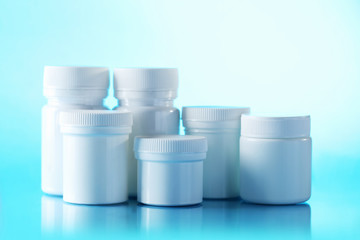White cosmetic bottles on a blue background