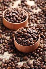 Brown roasted coffee beans in bowl on sackcloth