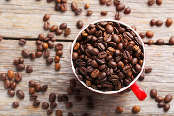 Roasted coffee beans in cup on a grey wooden table