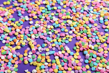 Colorful sprinkles on the purple background