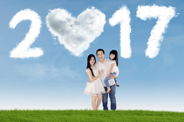 Asian family standing at field with 2017