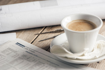 Newspaper business page with pen and cup of coffe