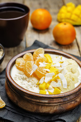 Oatmeal with mango, banana, tangerine oranges and coconut flakes