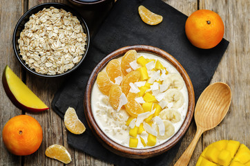 Oatmeal with mango, banana, tangerine oranges and coconut flakes