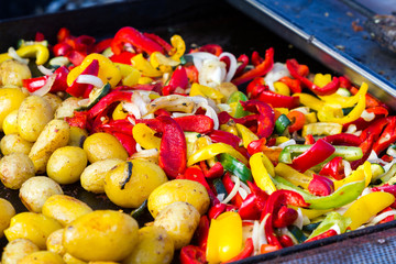 Baked potatoes and grilled vegetables in a large baking pan.