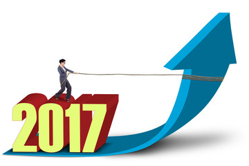 Businesswoman standing above number 2017 with arrow