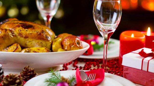 roasted chicken on christmas table in front of fireplace and tree with lights