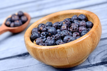 Juniper in a spoon and bowl on wooden table