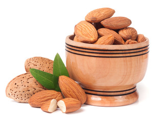heap of almonds in their skins and peeled with leaf isolated on white background