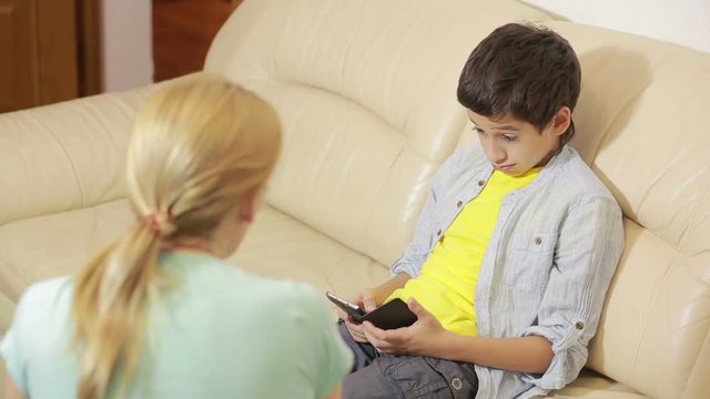 teen age son playing with phone, mother trying to talk