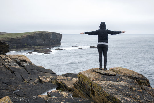 Girl looking Orkney coastline Yesnaby cliff landscape