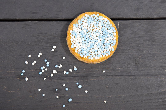 Traditional Dutch birth celebration biscuit with blue muisjes on wooden background