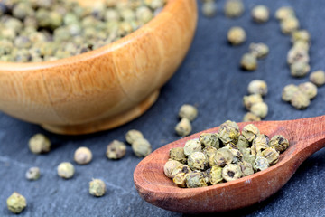 Green peppercorns in a spoon and bowl
