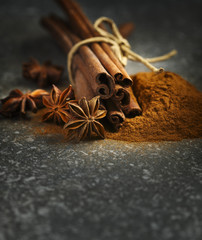 Cinnamon sticks, ground cinnamon and anice, selective focus