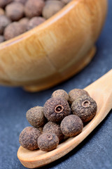 Allspice in a wooden spoon and bowl